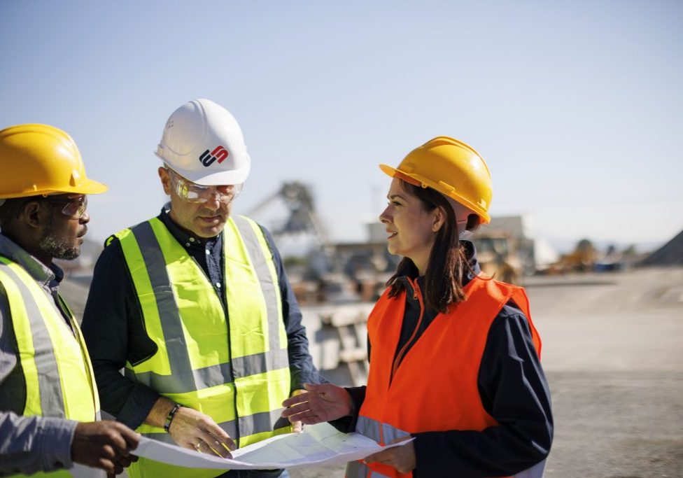 Engineers and architect discussing building plan at construction site